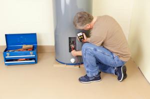 a Rockwall plumber is inspecting a water heater